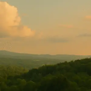 Serene golden hour landscape of rolling green hills and distant mountains under a warm sky with pastel clouds, symbolizing quiet strength, mindful living, and community support.